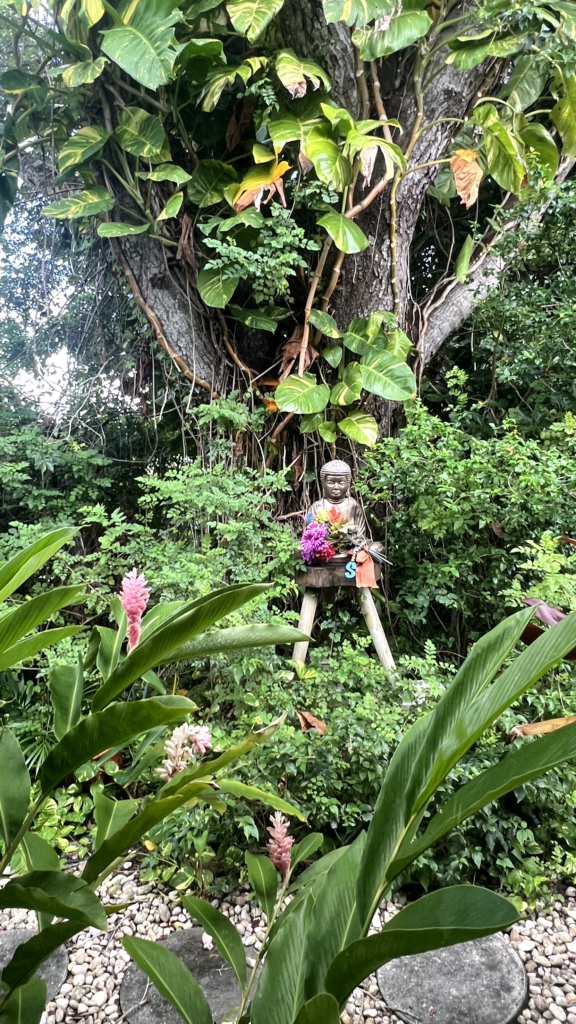 A statue of a person in the middle of a jungle.